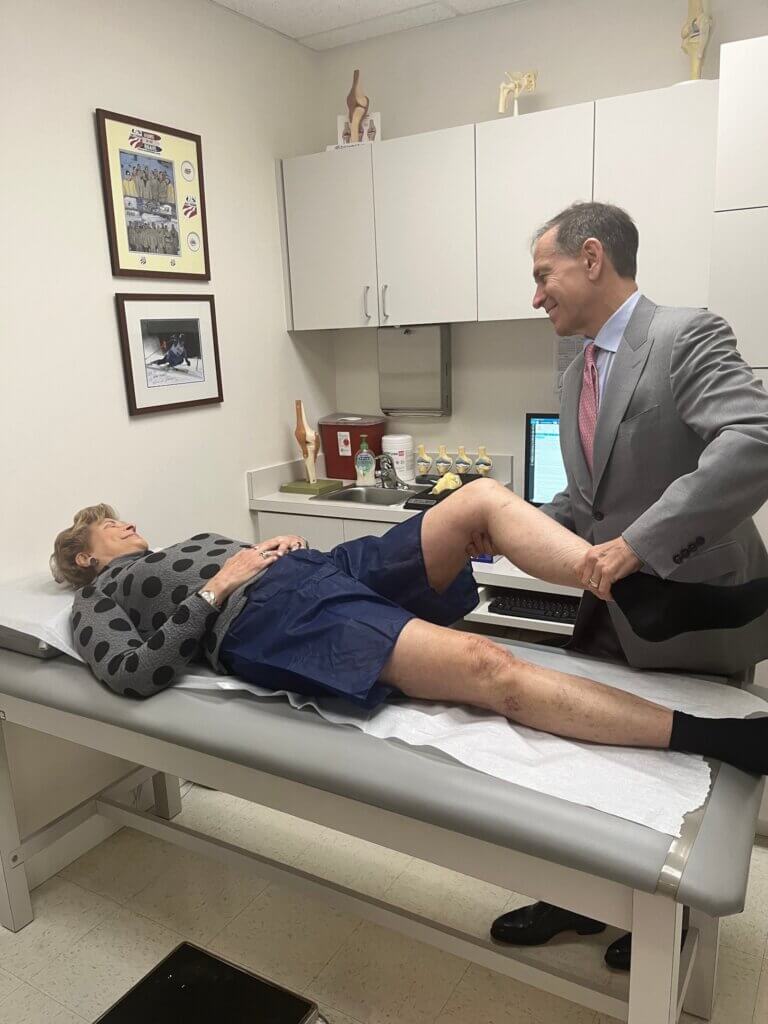 dr. kevin plancher with patient inspecting knee